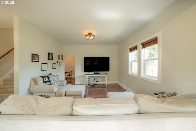 living room featuring stairs, baseboards, and wood finished floors