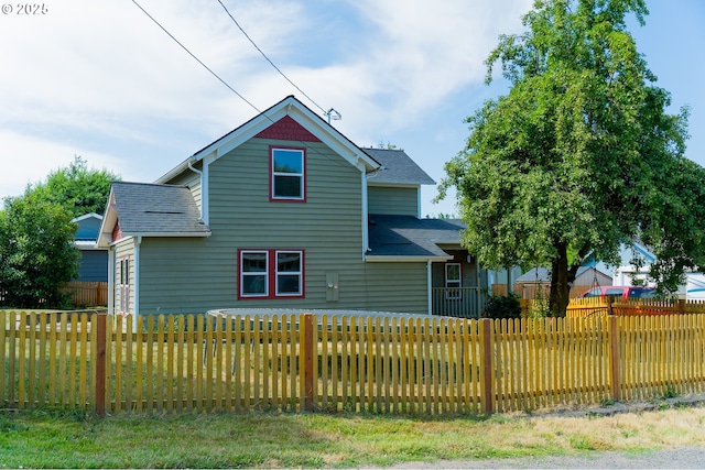 view of front of property featuring fence private yard and roof with shingles