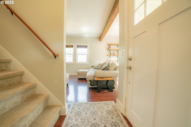 entryway featuring stairway, baseboards, beam ceiling, and wood finished floors