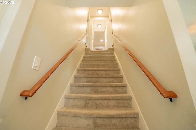 stairs with baseboards and carpet flooring