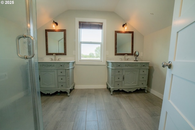 full bathroom featuring a sink, two vanities, wood finished floors, and lofted ceiling