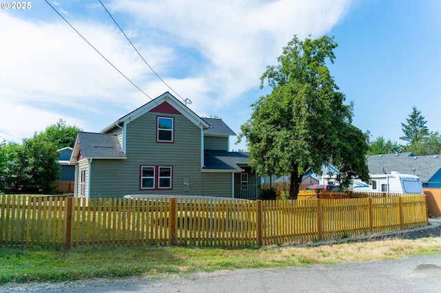 view of front of property with a fenced front yard and roof with shingles