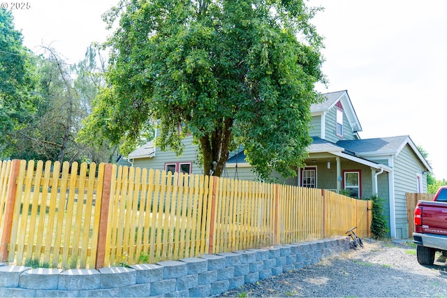 exterior space featuring roof with shingles and fence