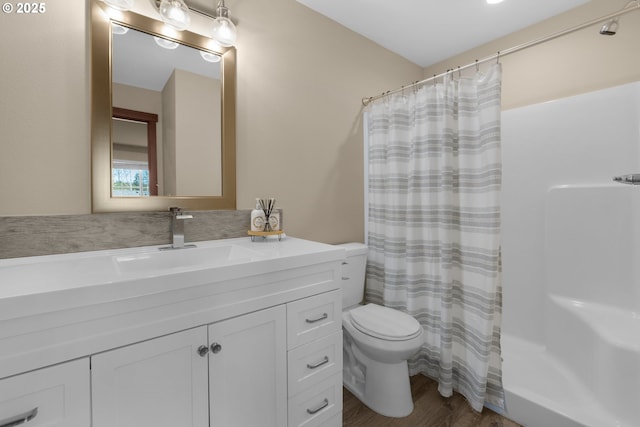 full bathroom featuring toilet, curtained shower, wood finished floors, and vanity