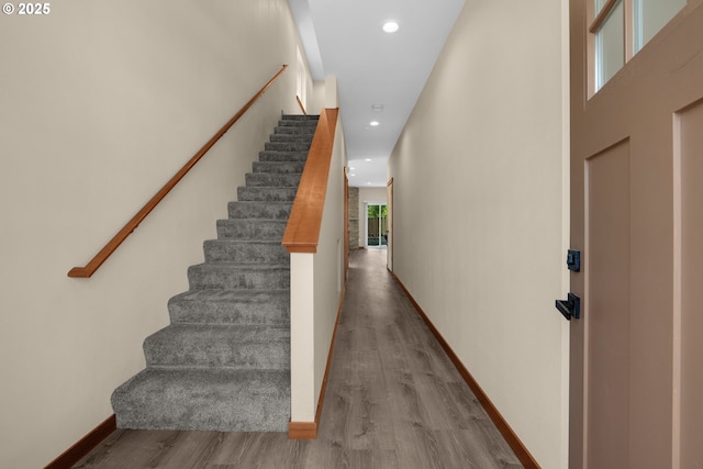 staircase featuring recessed lighting, baseboards, and wood finished floors