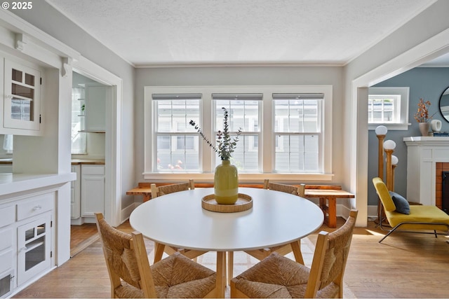 3620 NE 80th Ave, Portland, OR 97213 - dining space with healthy amount of natural light, a textured ceiling, light wood finished floors, a fireplace, and crown molding