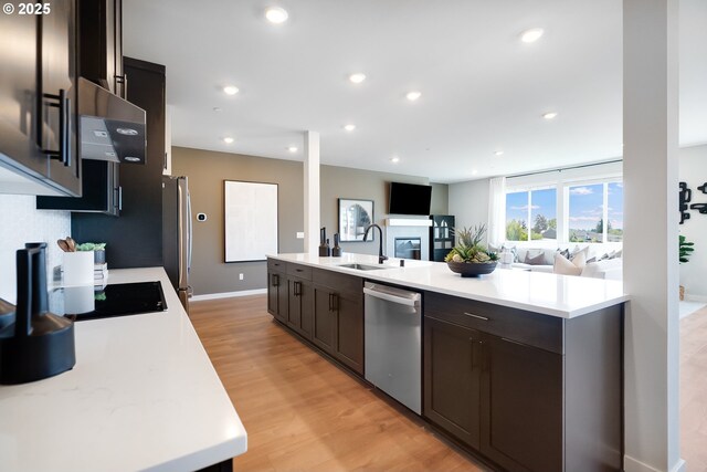 5591 N 87th Ave, Camas, WA 98607 - kitchen featuring appliances with stainless steel finishes, light countertops, light wood-style flooring, open floor plan, and dark brown cabinetry