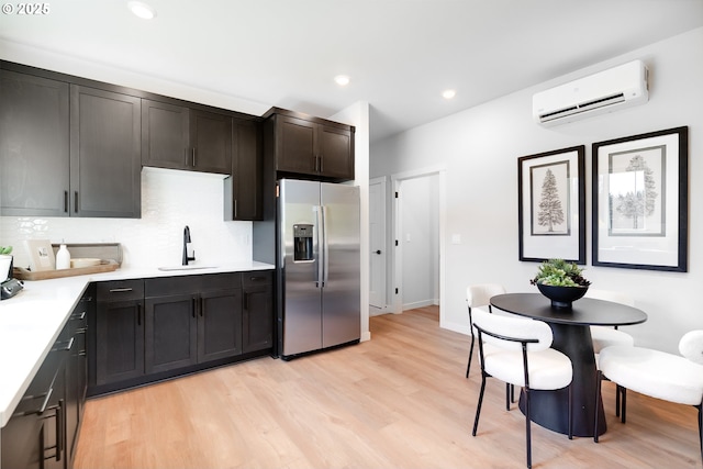 5591 N 87th Ave, Camas, WA 98607 - kitchen featuring stainless steel fridge, a wall unit AC, light wood-type flooring, light countertops, and decorative backsplash