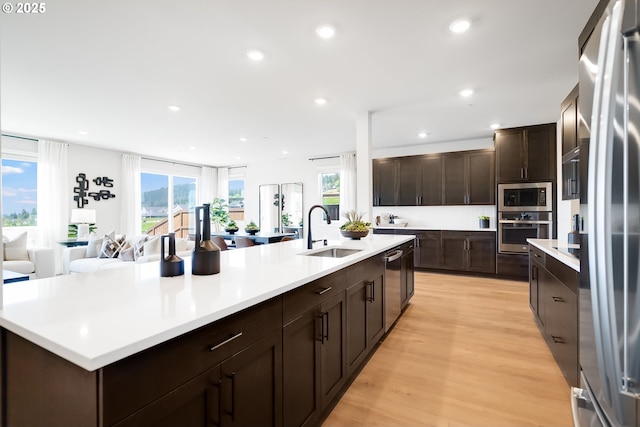 5591 N 87th Ave, Camas, WA 98607 - kitchen with appliances with stainless steel finishes, light countertops, light wood finished floors, dark brown cabinetry, and recessed lighting
