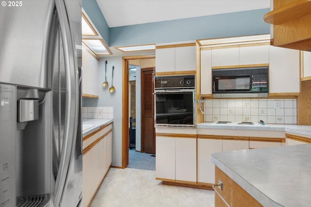 kitchen featuring black appliances, tasteful backsplash, and light countertops