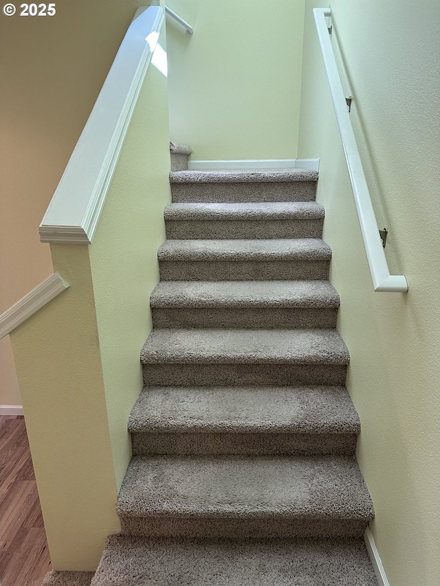 stairs featuring wood finished floors and baseboards