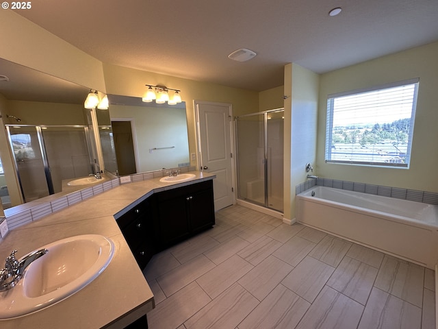bathroom featuring double vanity, a stall shower, and a bath