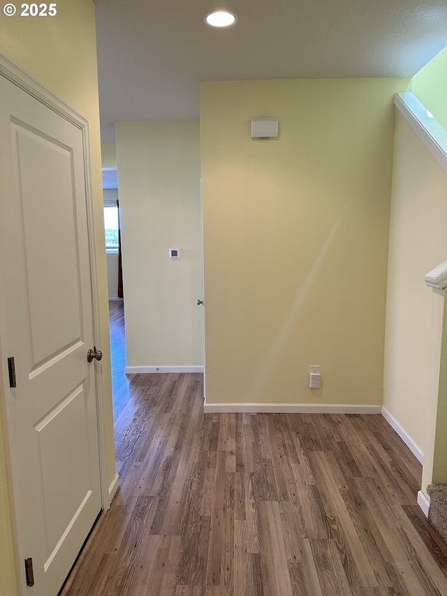 hall featuring baseboards, wood finished floors, and recessed lighting