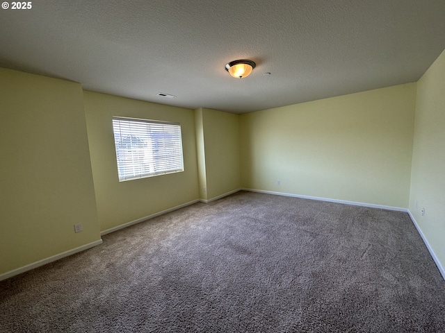 carpeted empty room featuring baseboards and a textured ceiling