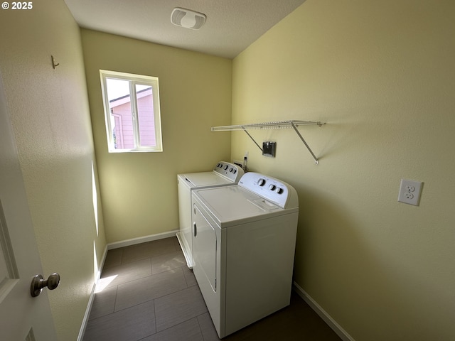 laundry area with washer and dryer, baseboards, and dark tile patterned flooring