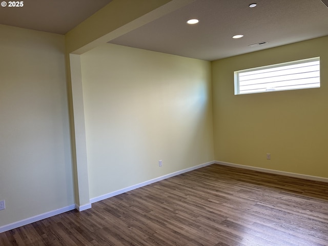 spare room featuring wood finished floors, recessed lighting, and baseboards