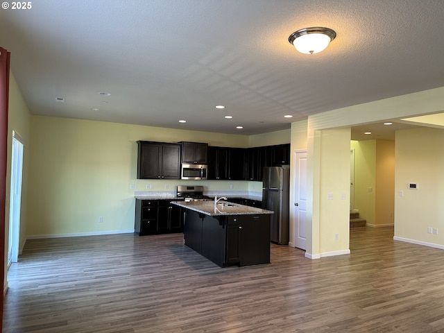 kitchen with appliances with stainless steel finishes, open floor plan, dark wood finished floors, baseboards, and recessed lighting