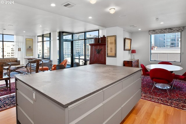 kitchen with open floor plan, visible vents, a healthy amount of sunlight, and light wood finished floors