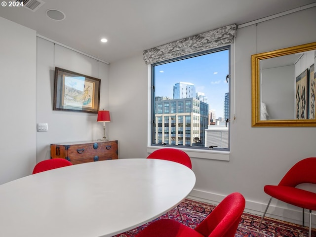 dining room with recessed lighting, baseboards, visible vents, and a city view