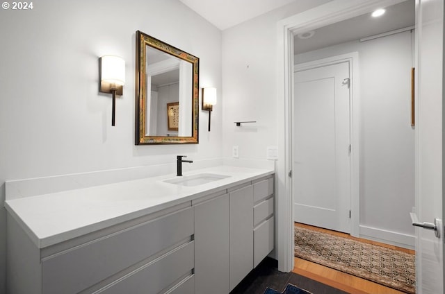 bathroom with vanity, baseboards, and wood finished floors