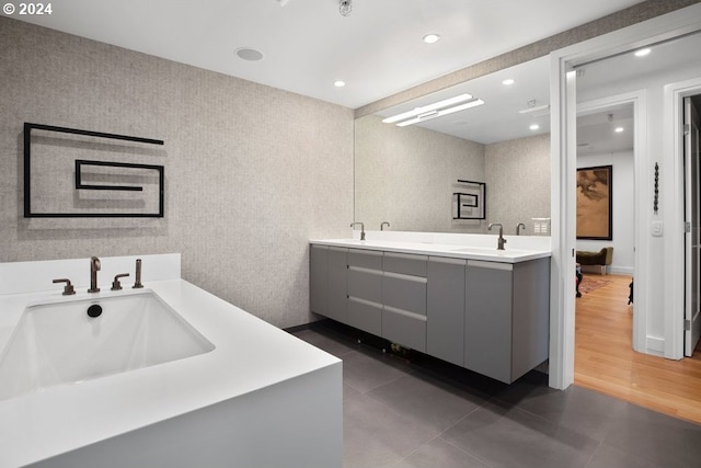 bathroom with recessed lighting, double vanity, a sink, and tile patterned floors
