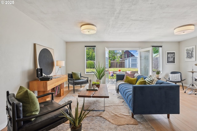 living area with healthy amount of natural light, wood finished floors, and baseboards