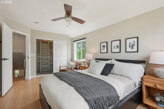 bedroom with light wood-style flooring, a closet, a ceiling fan, and vaulted ceiling