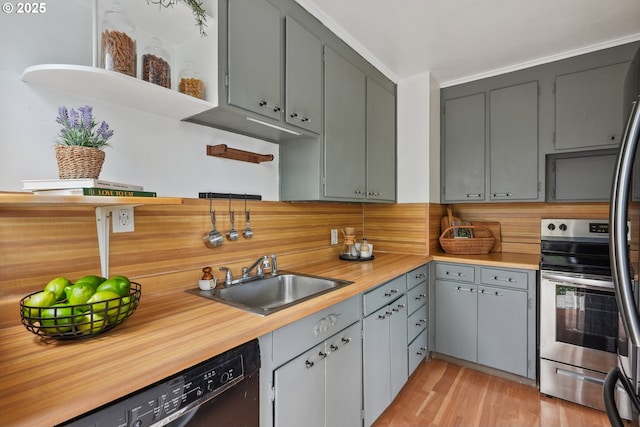 kitchen with dishwasher, electric range, a sink, light countertops, and light wood-type flooring