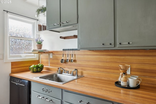 kitchen featuring dishwasher, a sink, gray cabinetry, and butcher block countertops