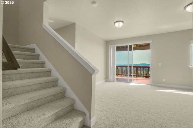 stairway featuring carpet floors and baseboards