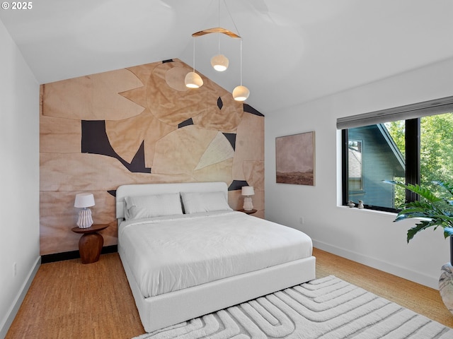 bedroom featuring lofted ceiling and baseboards