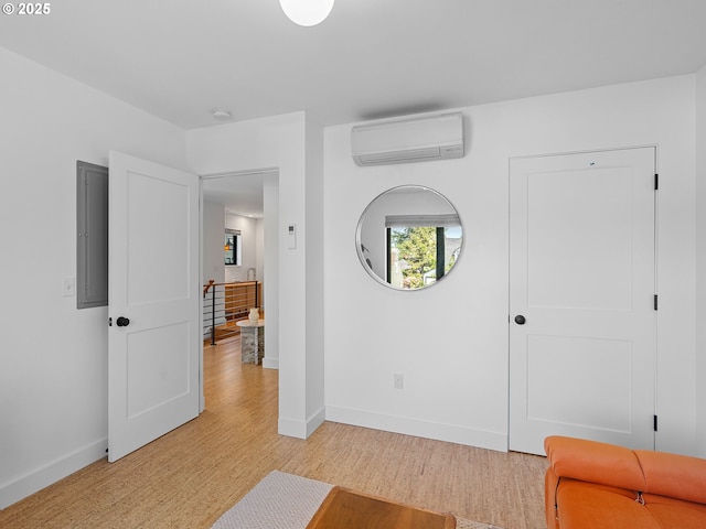 foyer featuring a wall unit AC, light wood-style flooring, and baseboards