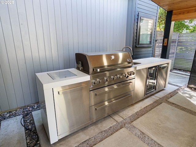 view of patio with area for grilling, a sink, and fence