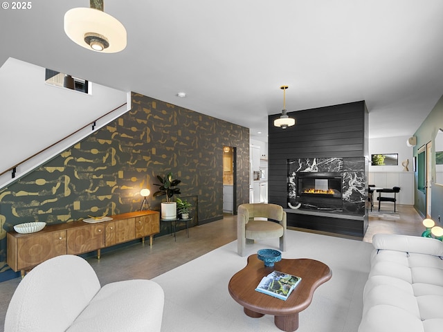 living area with wallpapered walls and a high end fireplace
