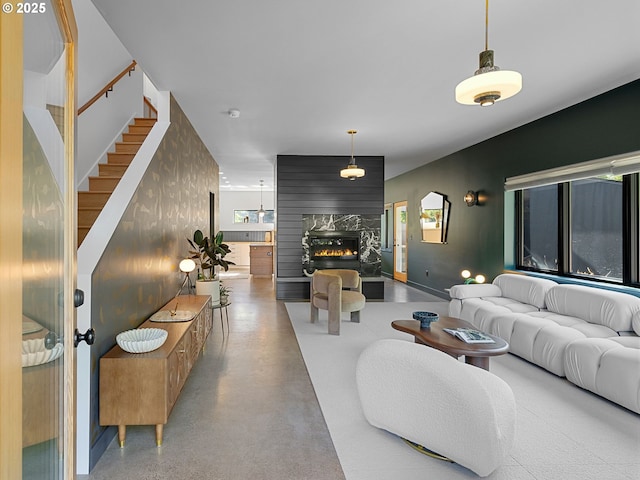 living area featuring a fireplace, stairs, and plenty of natural light