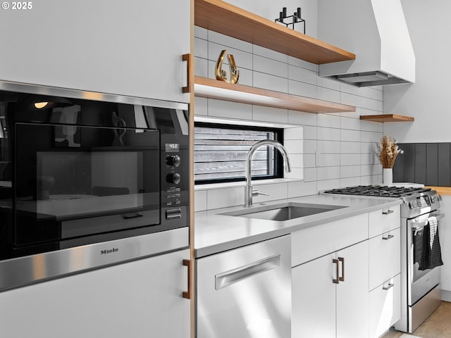 kitchen with open shelves, stainless steel appliances, backsplash, a sink, and white cabinets