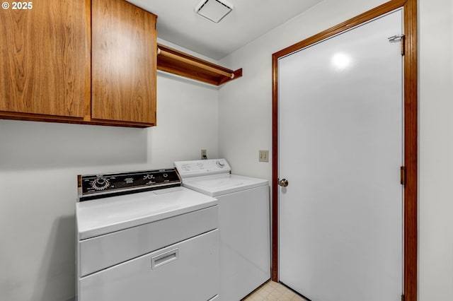 laundry room with separate washer and dryer, cabinet space, and light floors