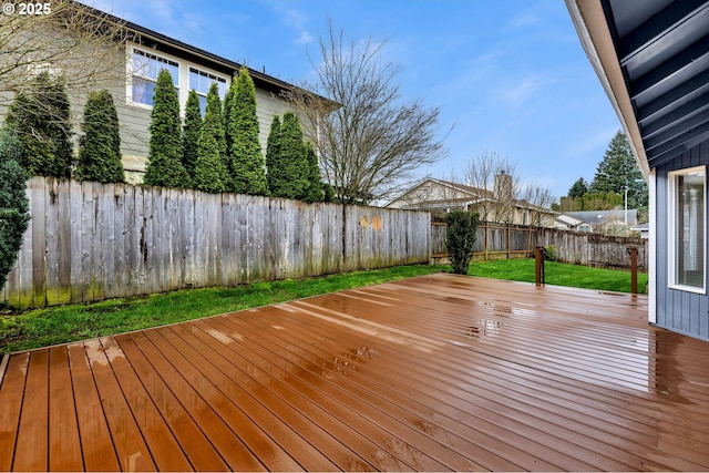 deck with a fenced backyard and a lawn