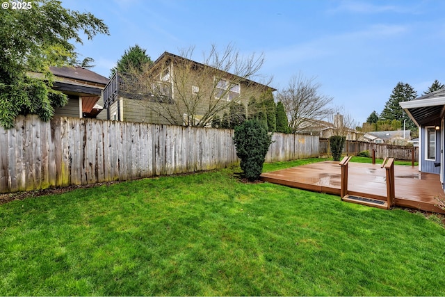 view of yard with a wooden deck and a fenced backyard