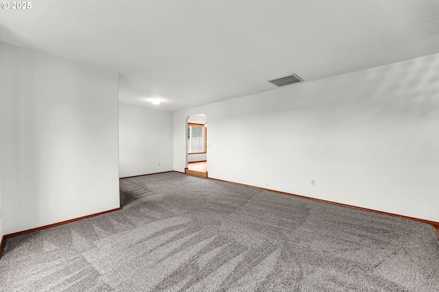 spare room featuring carpet flooring, baseboards, and visible vents