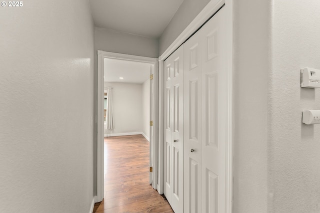 hall featuring baseboards and wood finished floors