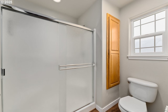 full bathroom with a shower stall, toilet, and baseboards