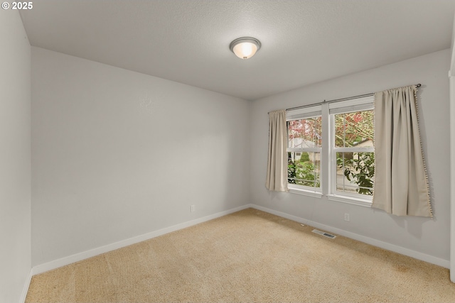 unfurnished room featuring visible vents, a textured ceiling, baseboards, and carpet floors