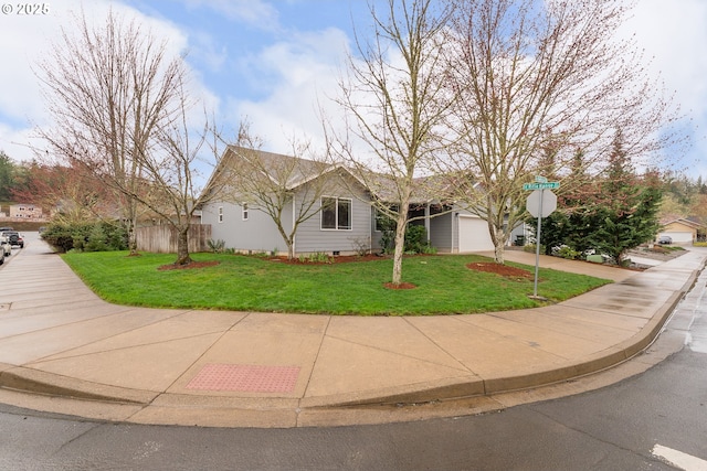 ranch-style home featuring a garage, driveway, and a front lawn