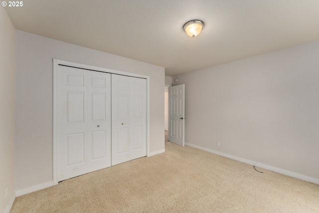 unfurnished bedroom featuring baseboards, a closet, and carpet floors