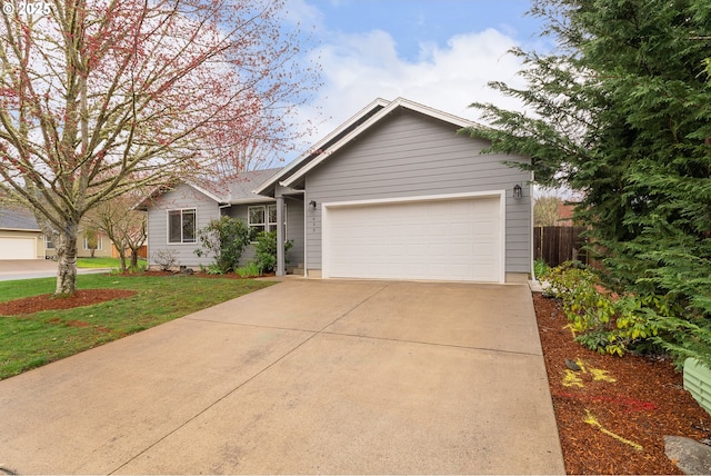 ranch-style home with driveway, an attached garage, a front yard, and fence