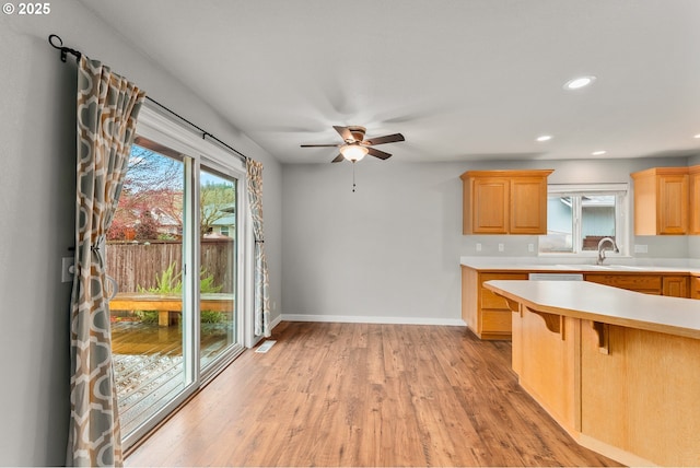 kitchen featuring light wood finished floors, baseboards, light countertops, recessed lighting, and a ceiling fan