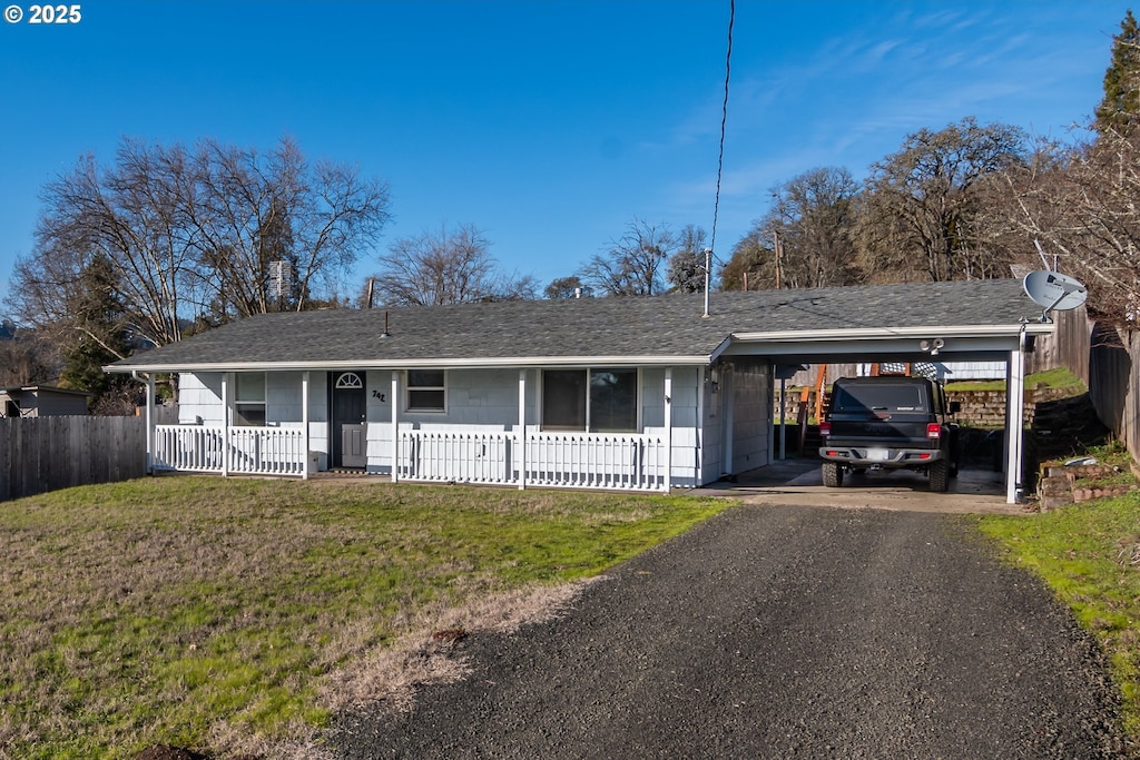 ranch-style house with a carport, a porch, and a front yard