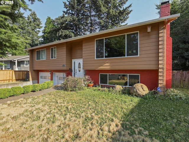 split foyer home with a garage and a front yard