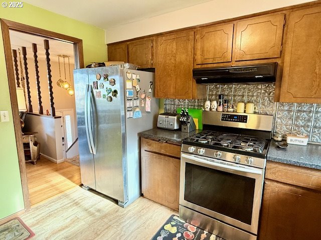 kitchen with tasteful backsplash, light wood-type flooring, and appliances with stainless steel finishes